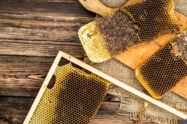 Jüt tutuyordu, üstten görünüm ile peteğin rustik ahşap zemin üzerine bal ile kaplı.