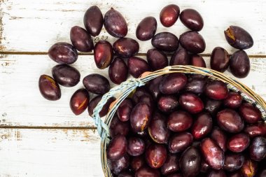 Ahşap arka plan üzerinde sepet içinde taze Erik Erik.