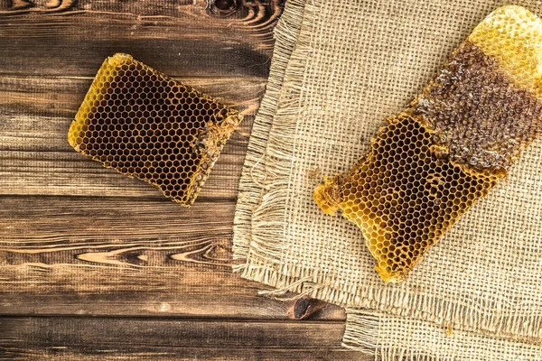 Jüt tutuyordu, üstten görünüm ile peteğin rustik ahşap zemin üzerine bal ile kaplı.