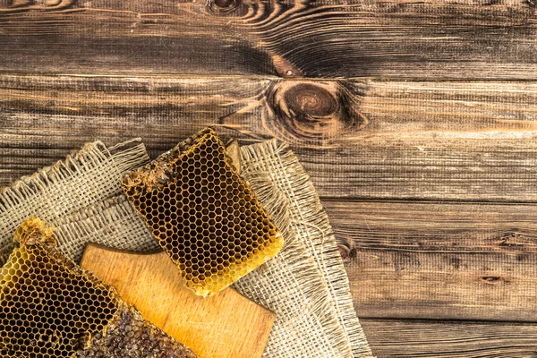 Jüt tutuyordu, üstten görünüm ile peteğin rustik ahşap zemin üzerine bal ile kaplı.