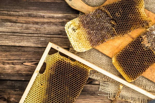 Jüt tutuyordu, üstten görünüm ile peteğin rustik ahşap zemin üzerine bal ile kaplı.