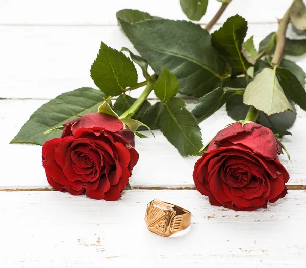 Red roses and engagement ring on wooden background — Stock Photo, Image