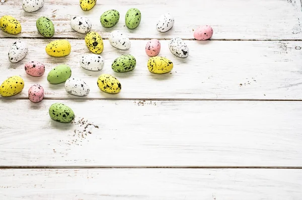 Fondo de Pascua con coloridos huevos de Pascua en tablas de madera blanca — Foto de Stock
