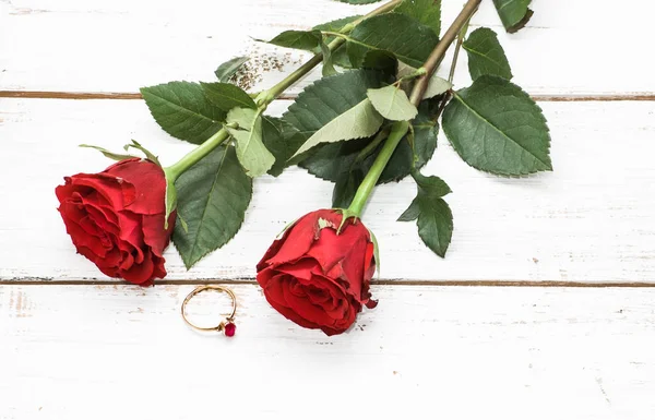 Czerwone róże i pierścionek zaręczynowy na podłoże drewniane, koncepcja zaproszenia ślubne — Zdjęcie stockowe