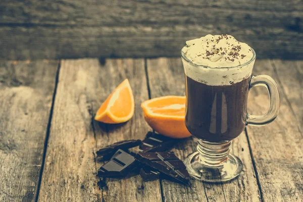 Bebida de chocolate quente com chantilly em uma xícara, sobremesa na mesa de madeira — Fotografia de Stock