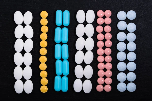 Hintergrund mit Medikamenten. Tabletten, Tabletten auf Darkboard. Arzneimittel und Medikamente. — Stockfoto