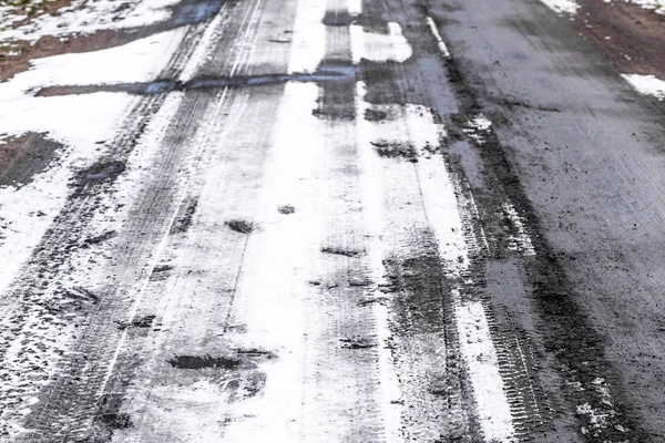 Winterliche Straßenbeschaffenheit, Reifenspuren in Schnee und Matsch — Stockfoto