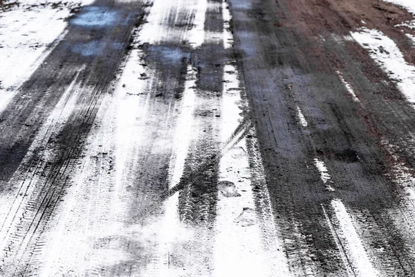 Nieve en la carretera con huellas de neumáticos, textura de invierno —  Fotos de Stock