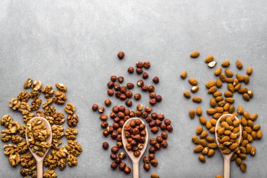 Fındık, fındık, badem ve ceviz tahta kaşık, gıda, sağlıklı superfood kavramı ile masa üzerinde karışımı