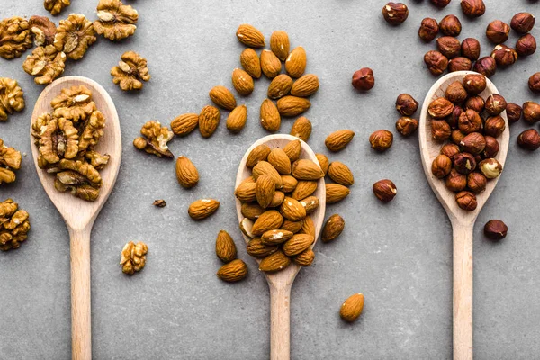 Noix mélangées sur cuillères, noix, amandes et noisettes, aliments sains, plat, frais généraux — Photo