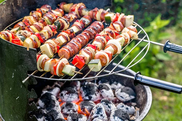 Groenten en vlees spiesjes op barbecue grill met warme gerechten, grillen buiten in de achtertuin van de zomer — Stockfoto