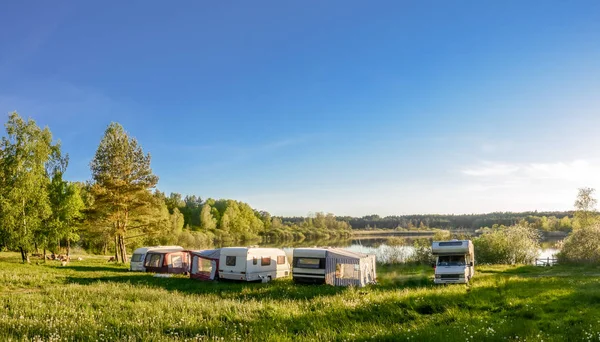 Przyczepy kempingowe i pole namiotowe nad jeziorem. Rodzinne wakacje na świeżym powietrzu, koncepcja podróży — Zdjęcie stockowe