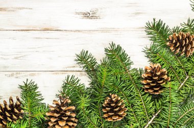 Çam kozalakları ahşap zemin üzerine yeşil Noel ağacı dalı süslenmiş