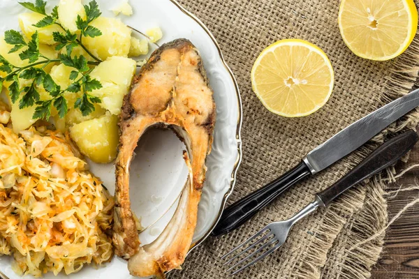 Ikan goreng dengan salad dan kentang, makan malam tradisional di atas piring, konsep memasak — Stok Foto