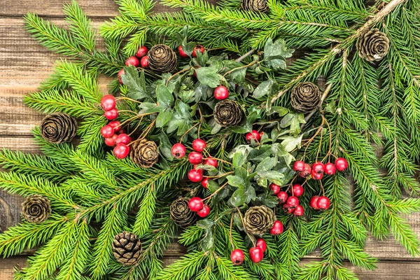 Fundo de Natal com ornamentos em ramos de abeto, decoração de férias em placas de madeira, vista superior — Fotografia de Stock
