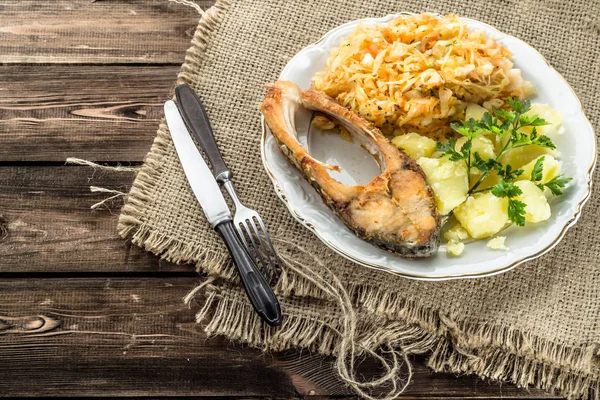 Smažené ryby s salát a brambory, tradiční večeři na desce, vaření koncepce — Stock fotografie