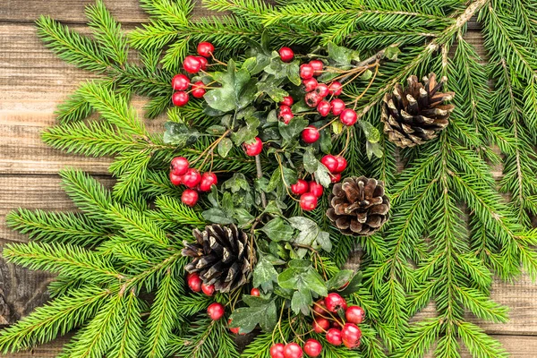 Weihnachtlicher Hintergrund mit Ornamenten auf Tannenzweigen, Feiertagsdekoration auf Holzbrettern, Draufsicht — Stockfoto