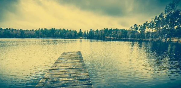 Drewniane molo nad jezioro, krajobraz, niebo moody — Zdjęcie stockowe