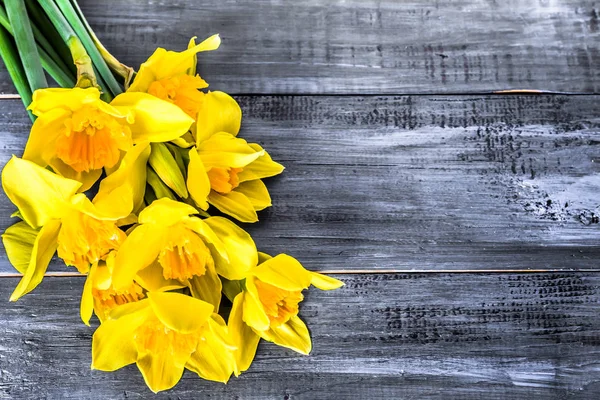 Keltainen daffodils kimppu valittu puinen tausta — kuvapankkivalokuva