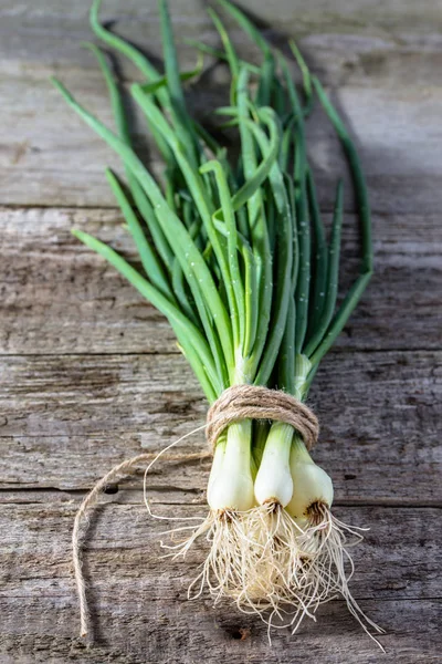 Un mazzo di cipolla verde sul tavolo di legno, verdure biologiche sul mercato locale — Foto Stock