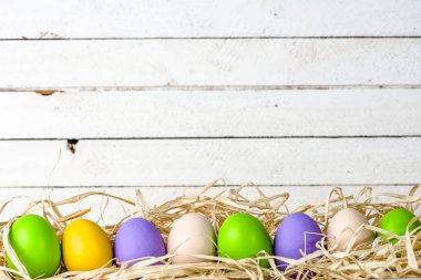 Ahşap arka plan Paskalya yumurtaları ile canlı renklerde boyanmış