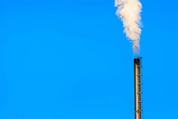 Power plant smokestack with carbon emission - co2, dioxide or fossil fuel. Air pollution by industry. Chimney and smoke cloud on blue sky background.