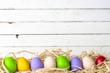 Saman içinde yumurta grup ile ahşap arka plan, beyaz kurullarında yuvadaki yumurta