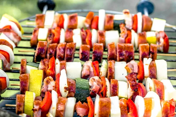Spiedini alla griglia con verdure e salsiccia alla griglia, barbecue all'aperto con cibi grigliati colorati, primo piano — Foto Stock
