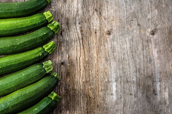 Moget zucchini, gröna grönsaker, ekologisk gård färskvaror på trä bakgrund — Stockfoto