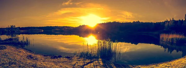 Sommerlandschaft mit Sonnenuntergang am See. wunderschöner orangefarbener Sonnenuntergang oder Sonnenaufgang über Wald und friedlichem Wasser mit Reflexion des Sonnenlichts, warme Landschaft in der Natur. — Stockfoto