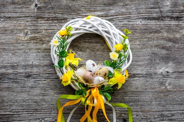 Fond de Pâques avec des œufs de Pâques de printemps et des fleurs, couronne sur la porte — Photo