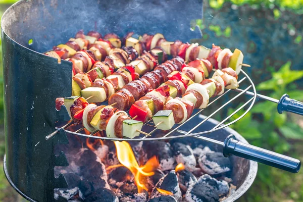 Zöldségek és a hús a nyársat a grill grill, mint a tűz és füst, gilling élelmiszer szabadtéri, a nyári kertben — Stock Fotó