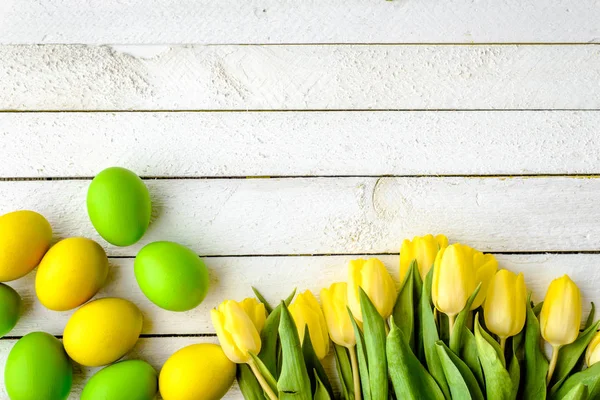 Oeufs de Pâques heureux, fond avec des tulipes et des œufs sur des planches en bois — Photo