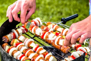 Yaz bahçesinde barbekü ızgara gıda hazırlama ile sebze ve et şiş, çimlerin üzerine barbekü dış taraf Cook'un eller ızgara