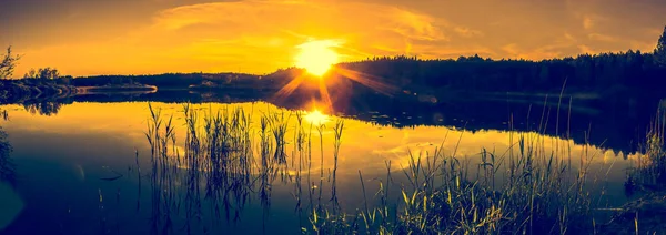 Paisaje de verano con puesta de sol en el lago. Hermosa puesta de sol naranja o salida del sol sobre el bosque y el agua pacífica con reflejo de la luz del sol, paisajes cálidos en la naturaleza . — Foto de Stock