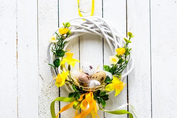 Easter background with spring easter eggs and flowers, wreath on door — Stock Photo, Image