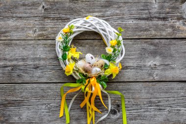 Paskalya arkaplanda paskalya yumurtası ve çiçekleri, kapıda çelenk