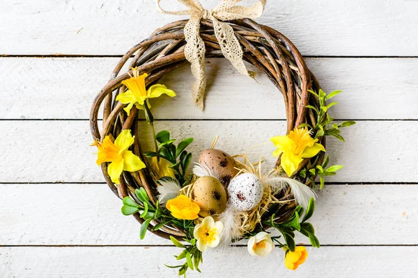Fond de Pâques avec des œufs de Pâques de printemps et des fleurs, couronne sur la porte — Photo