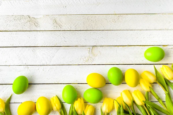 Fondo de madera con huevos de Pascua de primavera y tulipanes en la mesa, vista superior — Foto de Stock