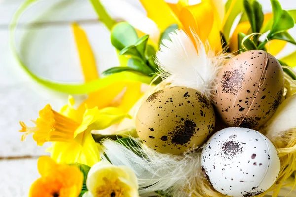 Великодній фон з весняними великодніми яйцями та квітами на дерев'яному столі — стокове фото