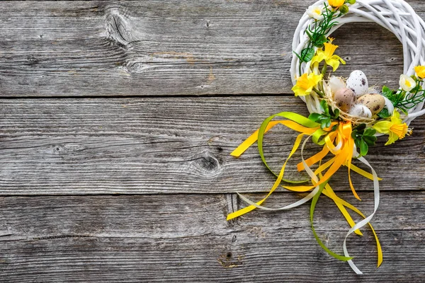 Fond de Pâques avec des œufs de Pâques de printemps et des fleurs, couronne sur la porte — Photo