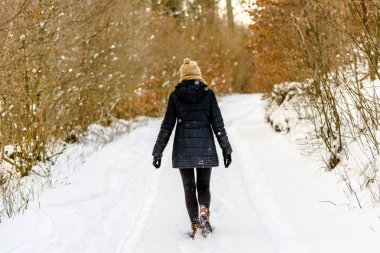 Kışın, ormanın içinde kar yolda yürüyen kadın