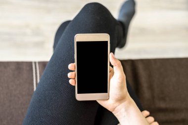 Kadın el istimal hareket eden telefon, smartphone ile ekran siyah renkte tutan kişi. Evde kanepede rahatlatıcı.