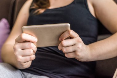 Oyun oynarken veya smartphone, film izlerken kişi ile hareket eden telefon, sakin ol ve rahat kanepe evde andan