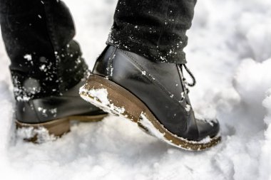 Karda, ayaklarda siyah ayakkabılar, kış modası moda erkek çizmeler