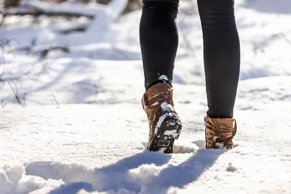 Female feet in boots and leggings, winter walking in snow Stock