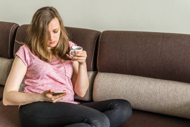 Cep telefonu ve kahve kanepe evde, insanların yaşam tarzı ve modern teknoloji gündelik hayatta kullanan kadın