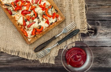 Ahşap arka plan üzerinde pizza bölümü.