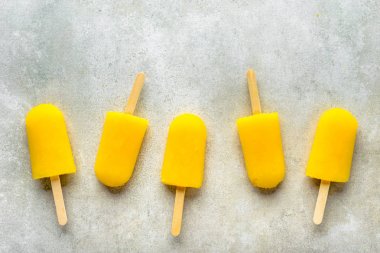 Ev yapımı dondurmayı portakal suyu ile buz şeker çubukları, üstten görünüm düz üzerinde yatıyordu