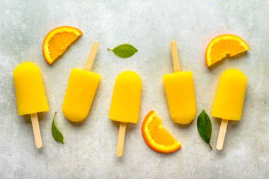 Ev yapımı dondurmayı portakal suyu ile buz şeker çubukları, üstten görünüm düz üzerinde yatıyordu